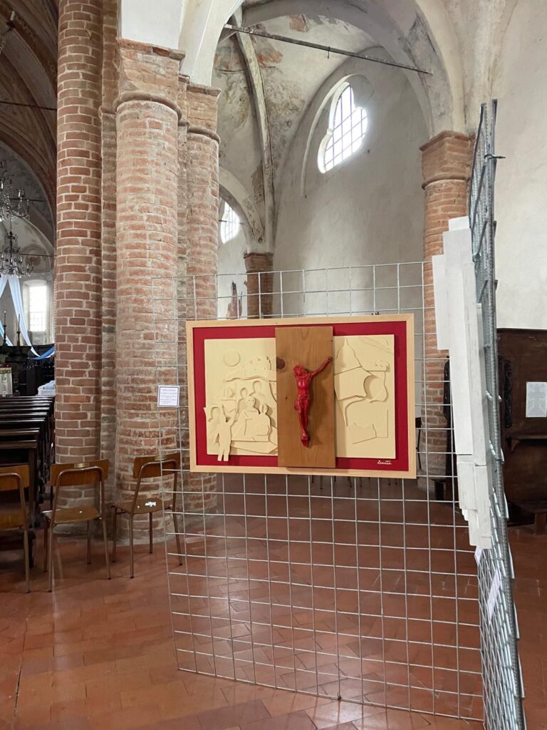Bassorilievo con crocifisso rosso allestito in una chiesa